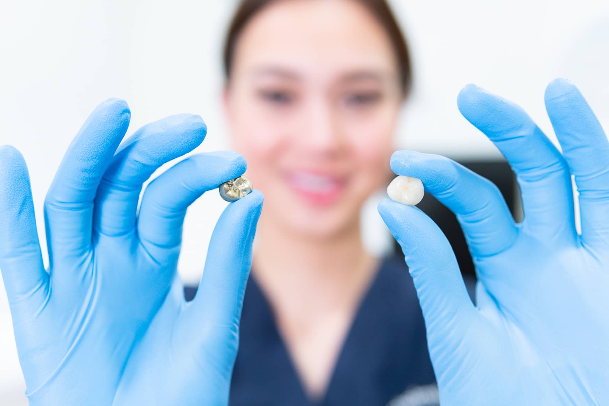 Dentist holding a tooth comparing it to the crown