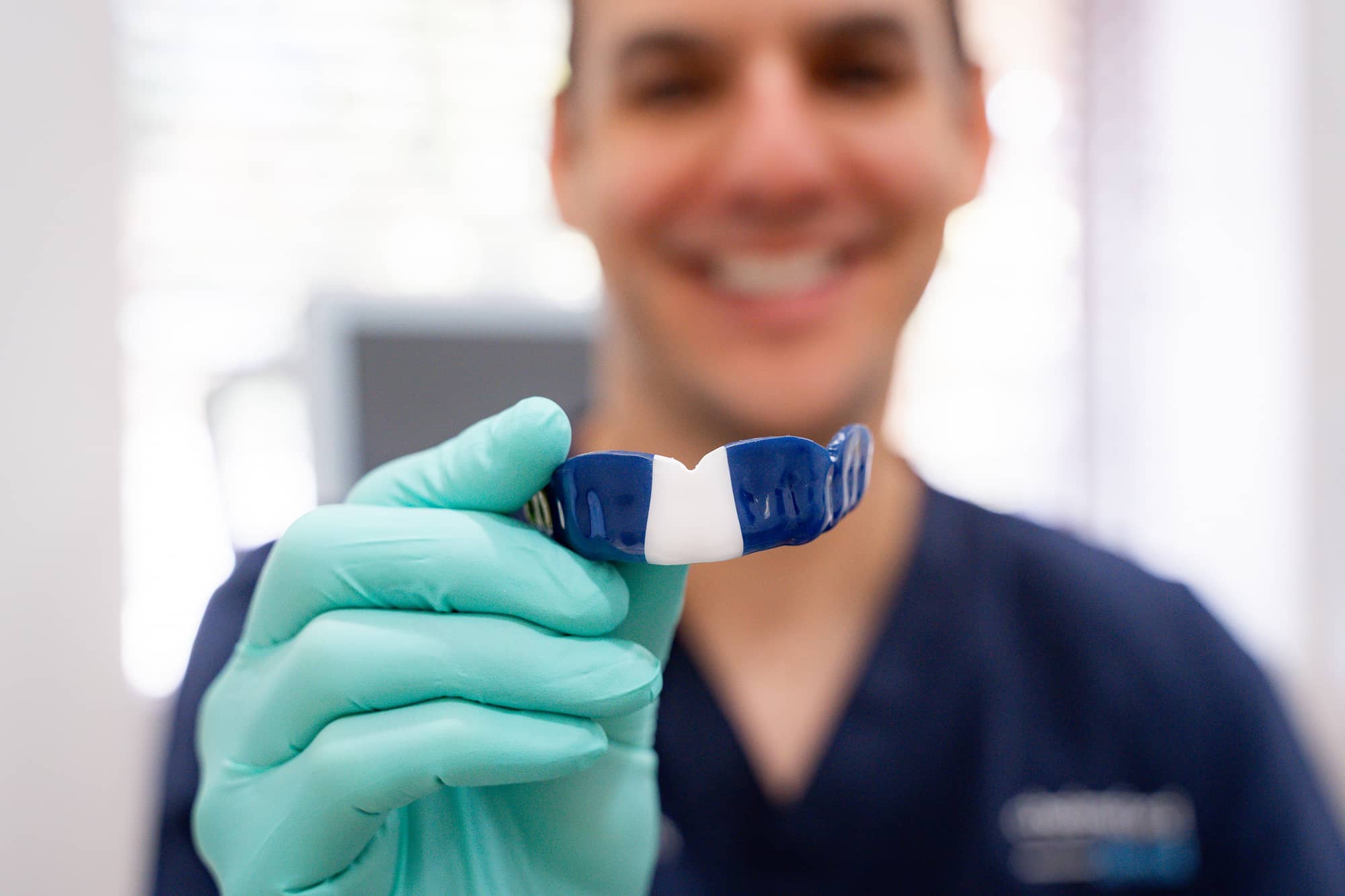 Dr. James holding custom mouth guard