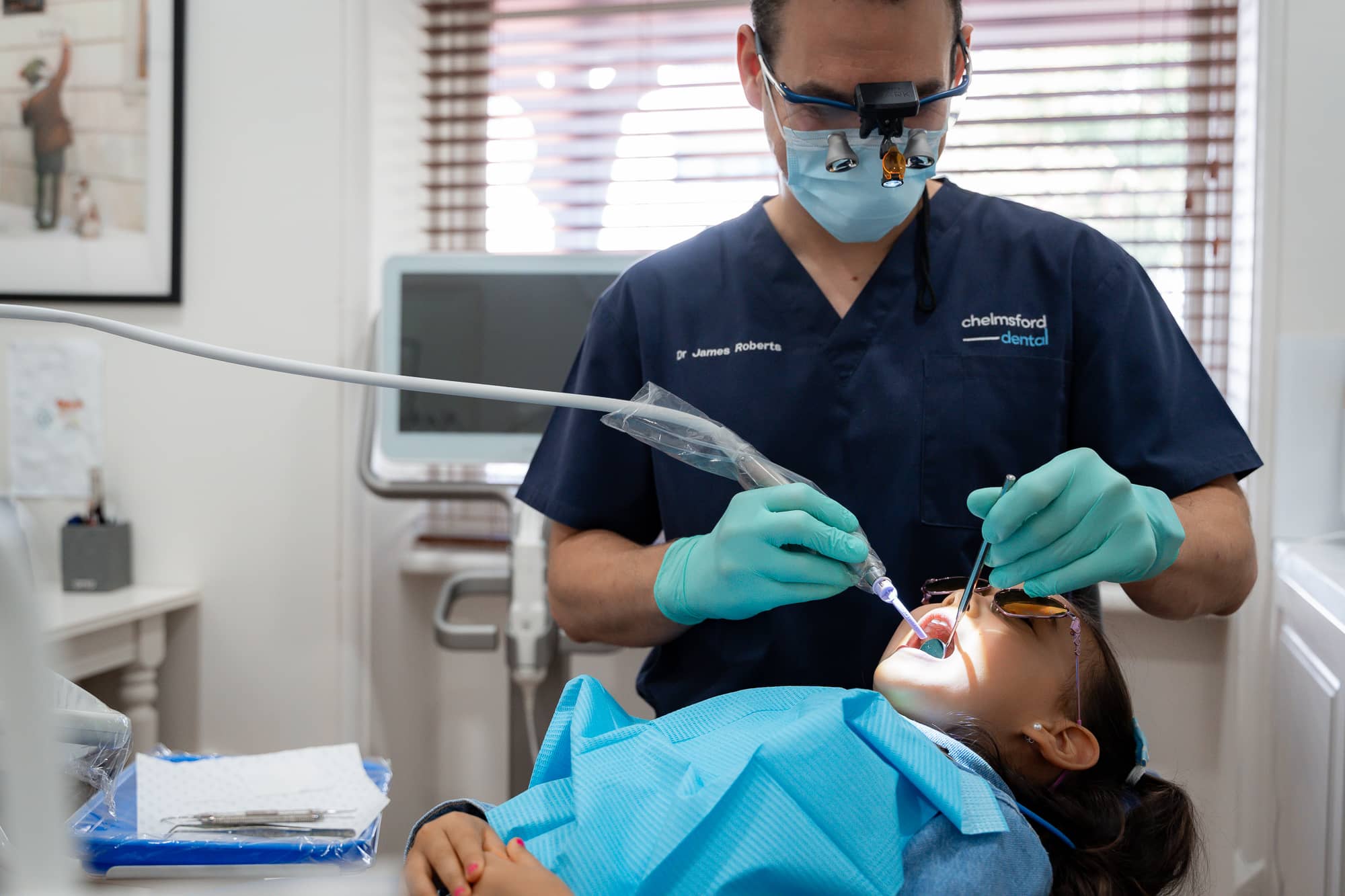 dentist cleaning child teeth at dental clinic