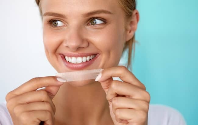 Teeth whitening strips work by slowly releasing hydrogen peroxide or other bleaching agents onto the teeth.
