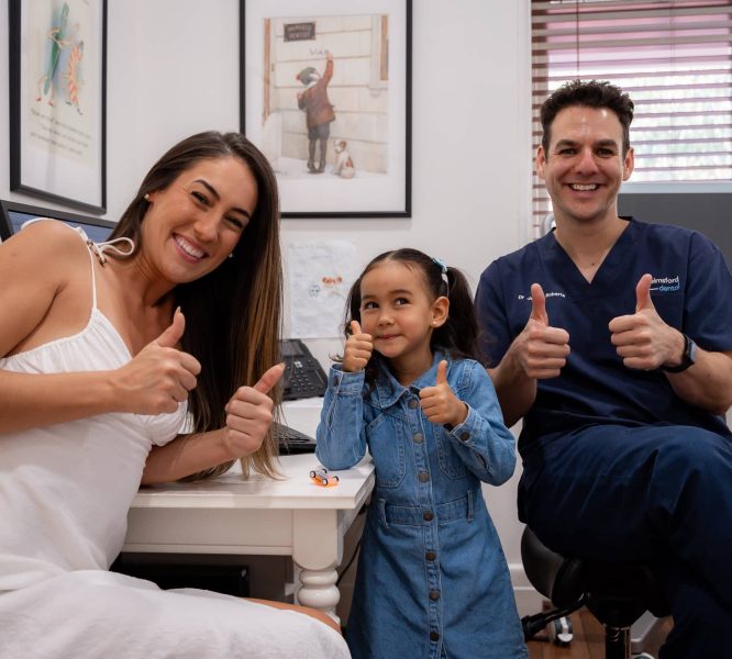 Dr James from Chelmsford Dental with smiling child and adult patient