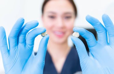 Dentist holding a tooth comparing it to the crown