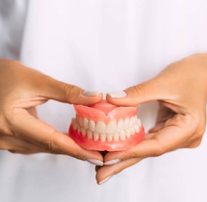 Dentist holding dentures.