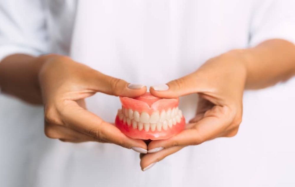 Dentist holding dentures.