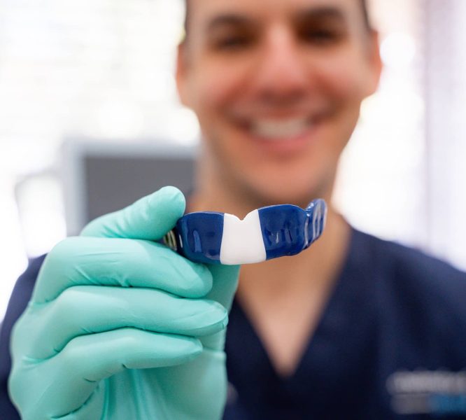 Dr. James holding custom mouth guard