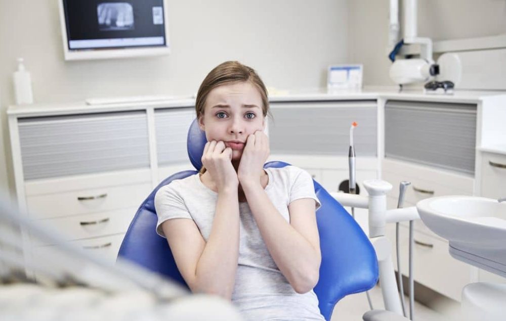 Terrified woman at dental clinic.